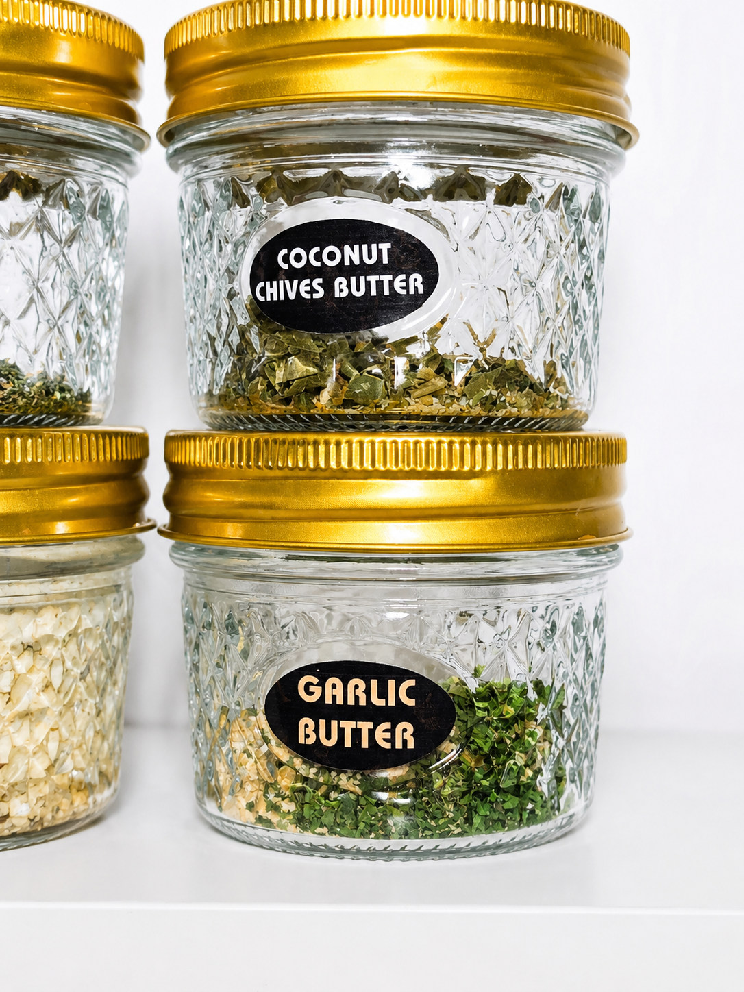 Three jars with gold lids containing different types of butter, labeled 'Coconut Chives Butter' and 'Garlic Butter'.