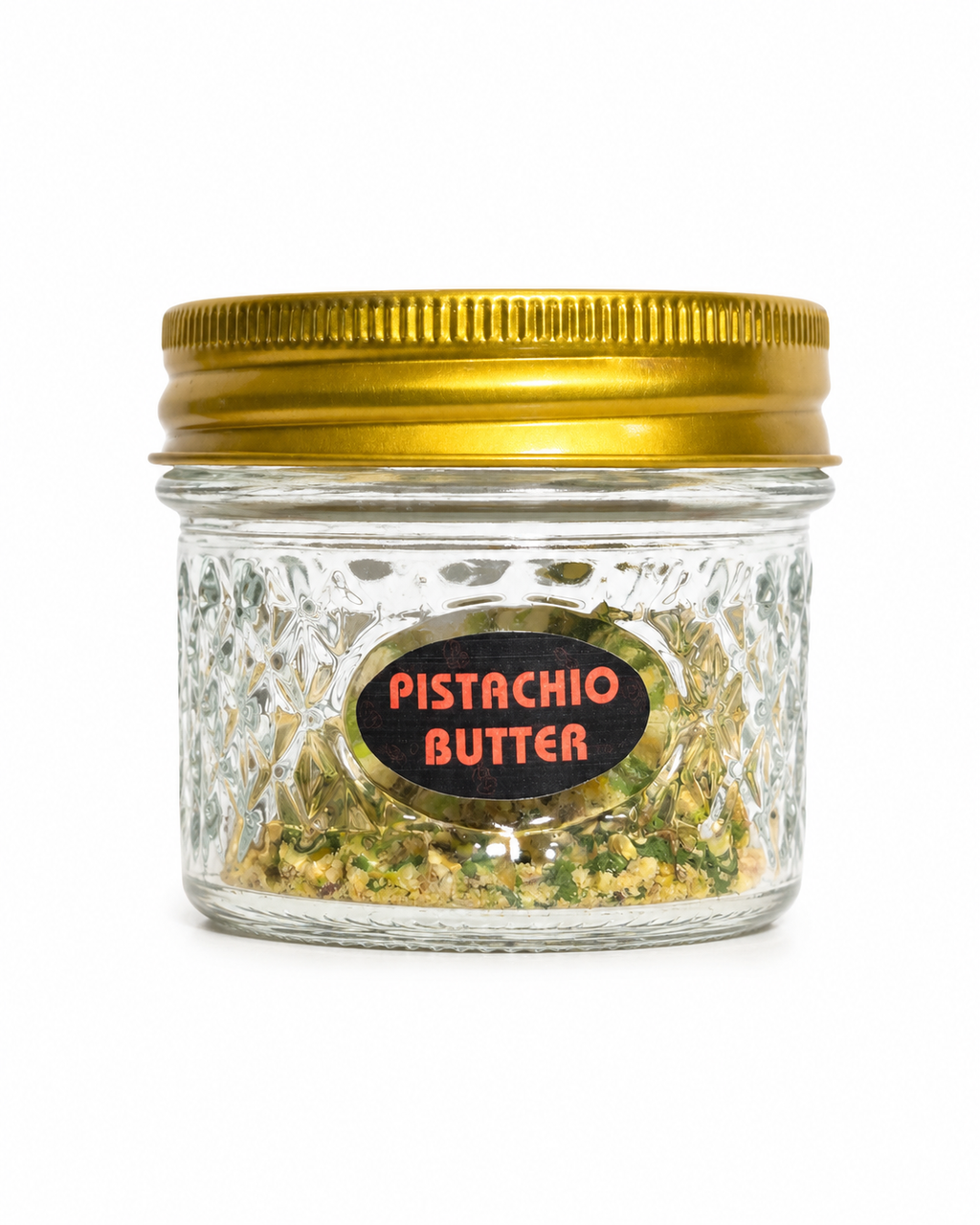 Jar of pistachio butter with a gold lid on a white background