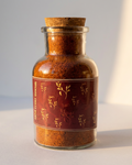 Glass jar with cork lid containing a spice mix on a light background